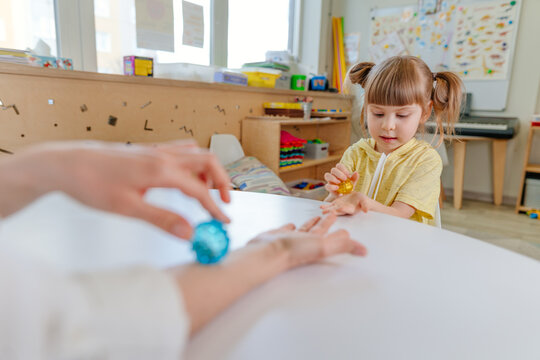 Girl on the lesson of the development of fine motor skills in kindergarten