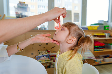 Girl on the session of speech therapist.
