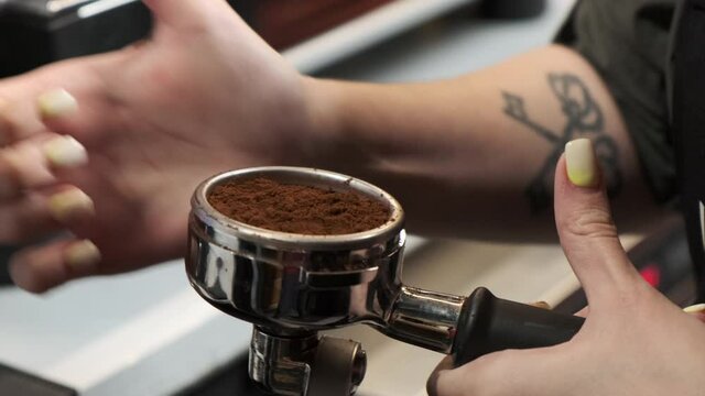 A girl presses coffee in a koyef tempera with her hand