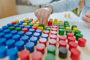 Preschool students playing with wooden mosaic in kindergarten