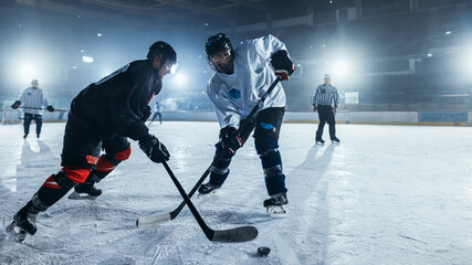 Ice Hockey Rink Arena: Two Professional Players From Different Teams Fighting for the Puck with Stick. Athletes Play Intense Game Wide of Energy Competition