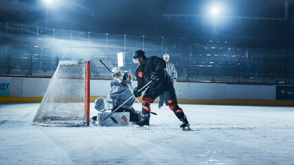 Ice Hockey Rink Arena: Goalie is Ready to Defend Score against Forward Player who Shoots Puck with...