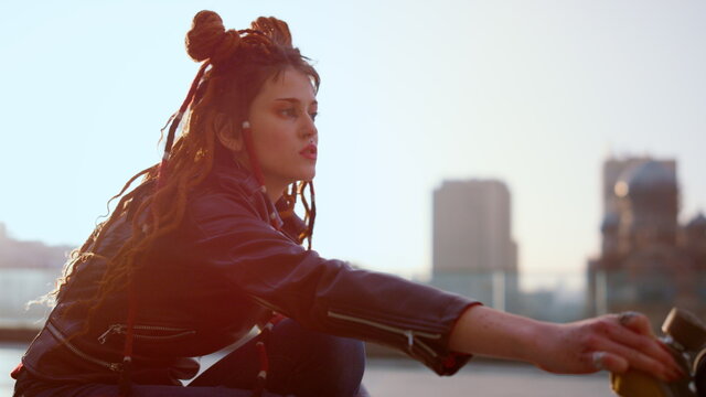 Young woman riding on rollerblades outside. Roller skater performing trick.