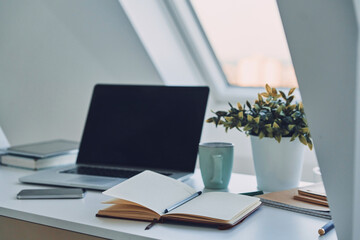 Image of laptop and note pad laying on the office desk