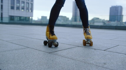 Sporty roller performing skating elements outdoor. Woman riding on rollerblades.