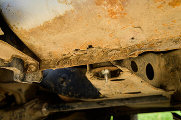 Rusty part of the car body with through-out corrosion. Background for cars requiring body repair
