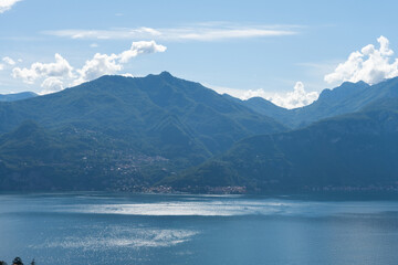 Beautiful view over the stunning lake Como in Lombardy, Italy. It is a very nice sunny summer day, with blue sky and a few white clouds. View is over the city of Menaggio.