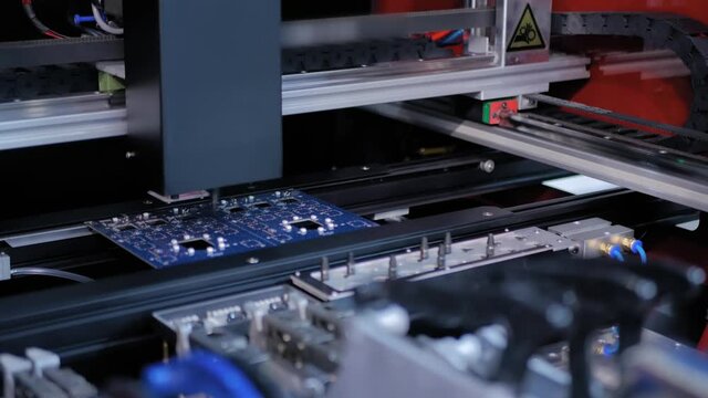 Assembly of computer circuit board - automatic SMD pick and place machine during work at factory. Automated technology, industrial, robotic, electronic, production, manufacturing concept