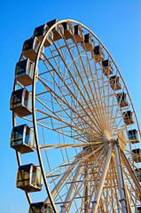 Ferris wheel on the background of blue sky. Ferris wheel in the sunset
