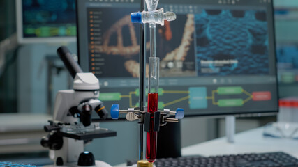 Close up of test tube and pipe for mixing solutions in laboratory on desk. Medical research equipment in glassware used on testing and chemistry experiment with microscope and computer