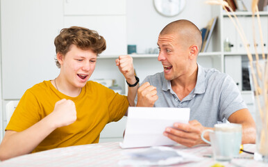 Fototapeta premium Happy son and father rejoice at the good news letter
