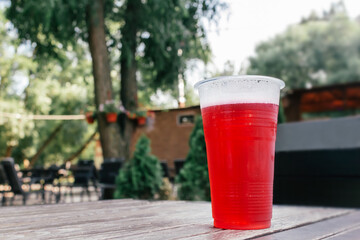 Red herry beer in glass on table.