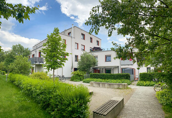 Residential area with ecological and sustainable green residential buildings, low-energy houses with apartments and green courtyard - obrazy, fototapety, plakaty