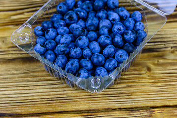 Blueberry in plastic box on a wooden table