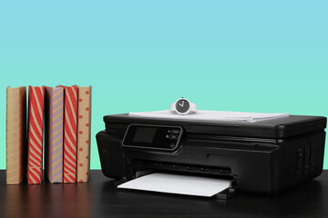 Home laser printer on desk against green background