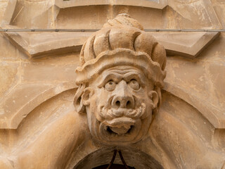 Grotesque face of a Moor wearing a turbante over a door of the Baroque Palazzo Beneventano, Scicli