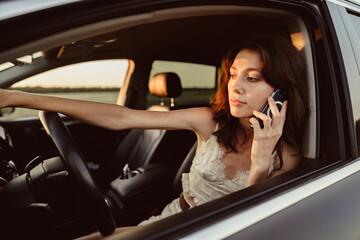 Portrait of woman talking on mobile phone while driving her car