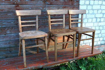 Three wooden chairs dry in the air after being varnished. repair of old chairs.