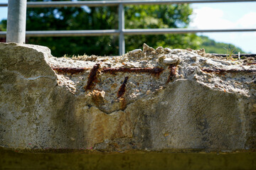 Rusty structural steel and flaking concrete parts on a bridge