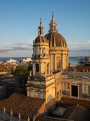 Catania Cathedral dome and tower over the city roofs with the port in background
