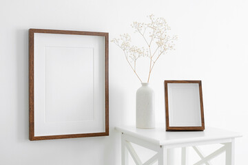 Portrait wooden frames mockup for artwork, photo and print presentation. White walll with furniture...