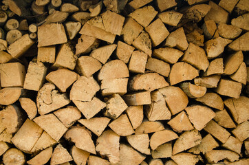 Stacked firewood close-up. Firewood storage close up. Stocks of wooden logs close-up. Chopping wood. Rustic lifestyle. Wooden texture.