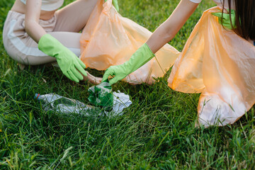 A group of girls with children at sunset are engaged in garbage collection in the park....