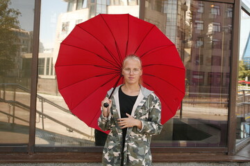 young girl with red umbrella in the city