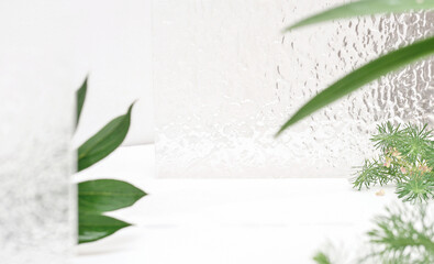 Cosmetics product bathroom stage. white display with green leaves on a glass background. Empty...
