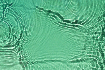 Water spills on a light green background. Natural sunlight and shade. Beautiful bursts and glare. Summer mood. Minimal style.