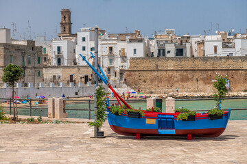 symbol regionu Puglia na południu Włoch czyli niebieska, bardzo intensywnie kolorowa łódź rybacka - obrazy, fototapety, plakaty
