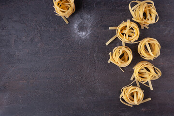 Tagliatelle pasta on a brown textured stone.
