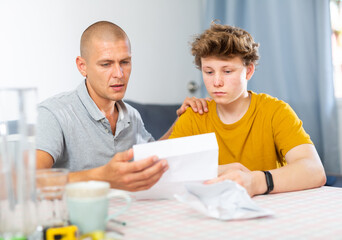 Obraz na płótnie Canvas Father and son upset after reading college letter