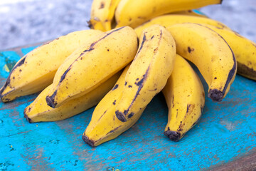 BANANAS ORGANICAS MADURAS EM CIMA DE UMA MADEIRA VELHA.