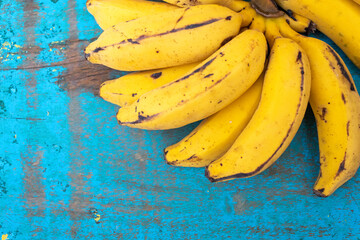 BANANAS ORGANICAS MADURAS EM CIMA DE UMA MADEIRA VELHA.
