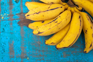 BANANAS ORGANICAS MADURAS EM CIMA DE UMA MADEIRA VELHA.
