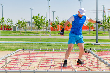 Sportsman receiving tire obstacle course training on sport field.