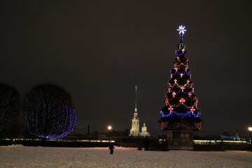 A quiet Christmas evening at the Christmas tree on the background of the beautiful Peter and Paul Cathedral