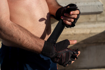 detail of a man's hands putting on gloves to train