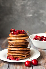 American breakfast. Chocolate pancakes with cherries. Pancakes with jam. Summer breakfast with fresh berries