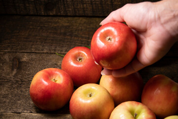 A woman lays out apples on a wooden table .Fresh bright fruits and berries on a wooden background.
