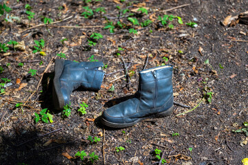Old winter men's boots with locks lie on the ground.
