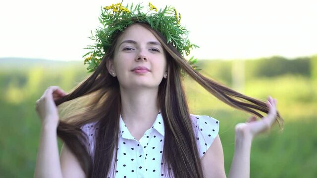 Woman puts a wreath of wild flowers on her head