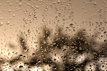 Water droplets on the window glass on a hot rainy summer afternoon