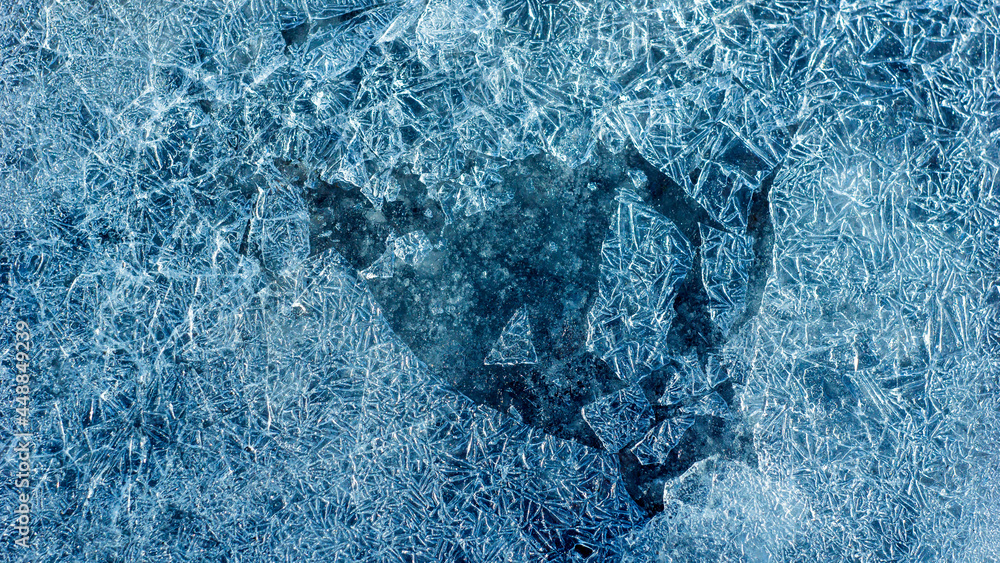 Poster beautiful ice texture with cracks of a frozen puddle on the asphalt for 3d texturing or design.