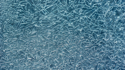 Beautiful ice texture with cracks of a frozen puddle on the asphalt for 3d texturing or design.