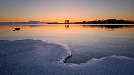 sunrise over the lake and snow and ice in the foreground