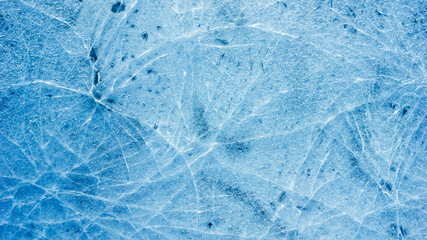 Beautiful ice texture with cracks of a frozen puddle on the asphalt for 3d texturing or design.