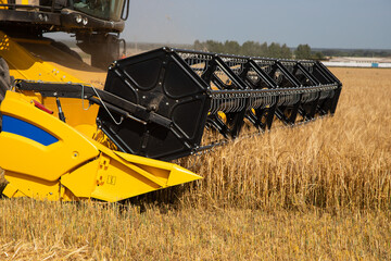 Fototapeta premium Combine harvester harvests wheat closeup.