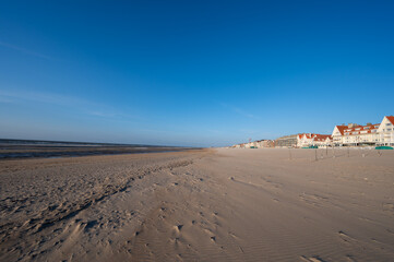 Yellow sandy beach in small Belgian town De Haan or Le Coq sur mer, luxury vacation destination, summer holidays